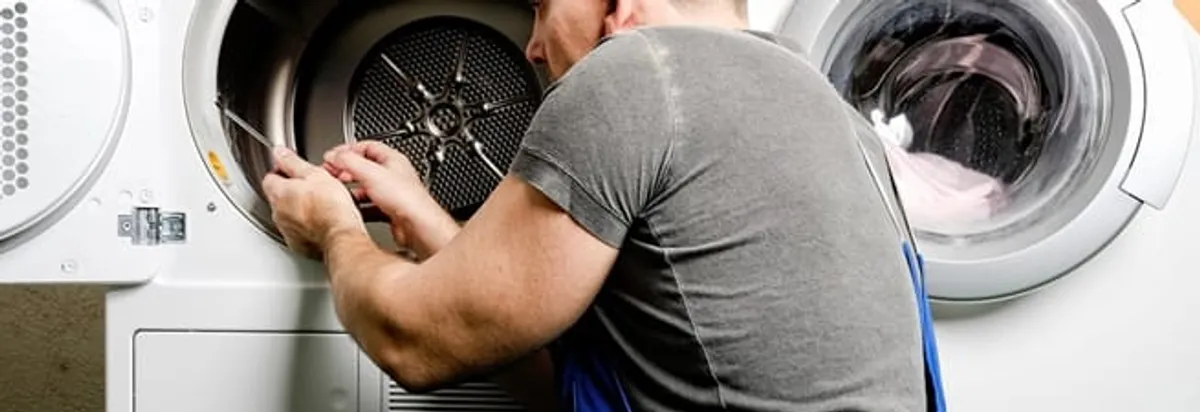 Dryer repair technician fixing a clothes dryer drum in Buffalo, NY