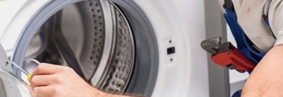Appliance technician repairing a clothes dryer drum and internal parts in Buffalo, NY