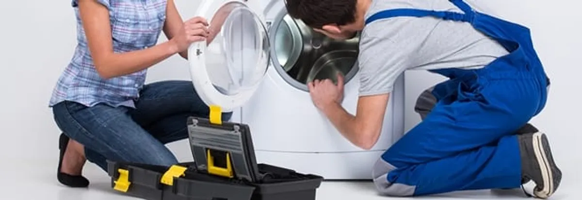 Washer repair technician inspecting a front-load washing machine with tools in Buffalo, NY