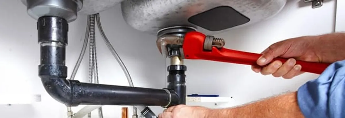 Garbage disposal repair technician tightening the sink drain and disposal connection in Buffalo, NY