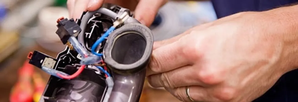 Vacuum repair technician reconnecting wiring and components in Buffalo, NY