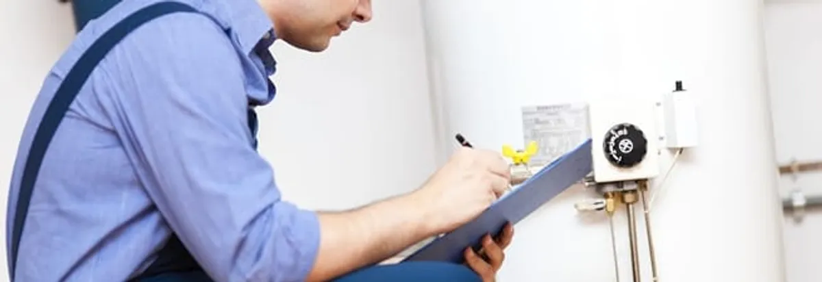 Water heater repair technician inspecting the unit and recording service notes in Buffalo, NY