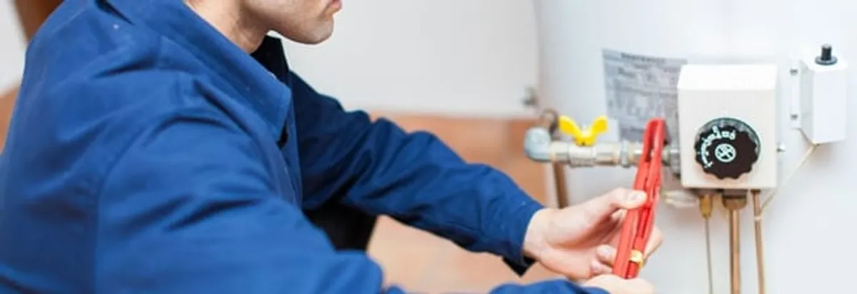 Water heater repair technician adjusting the temperature control and gas valve in Buffalo, NY